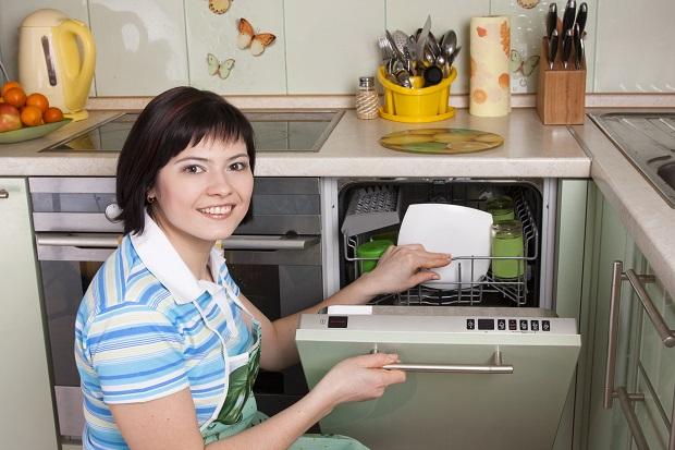 Женщина пользуется посудомоечной машиной 