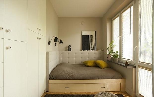 Маленькая спальня с молочными стенами и шкафом