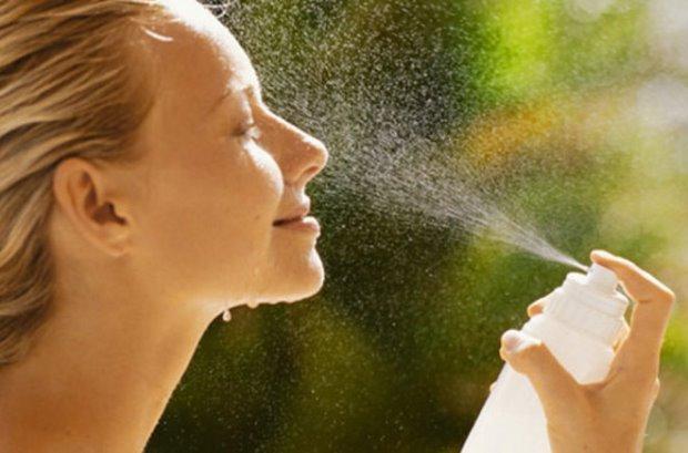 женщина брызгает воду на лицо