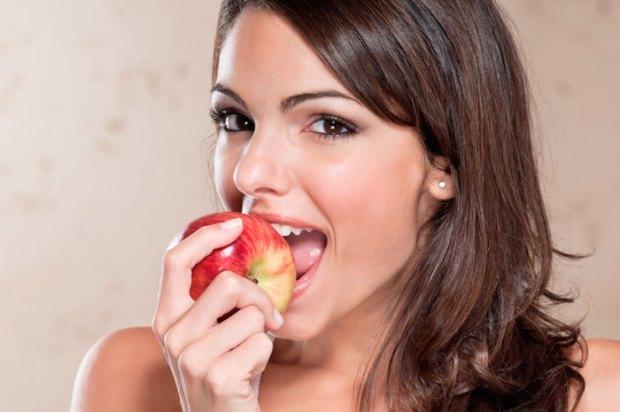 шатенка ест яблоко