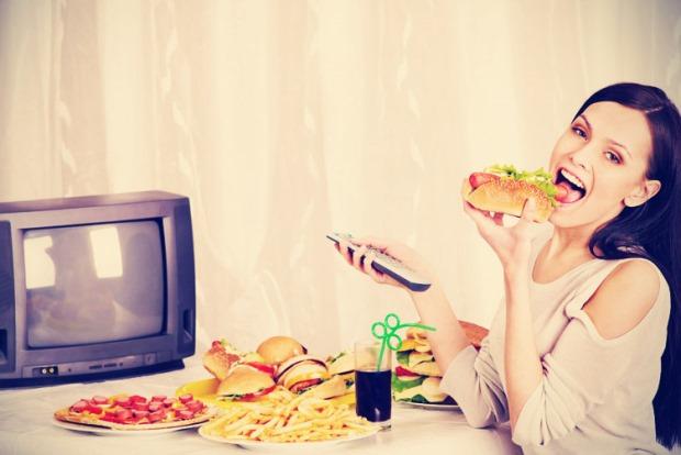 женщина ест у перед телевизором