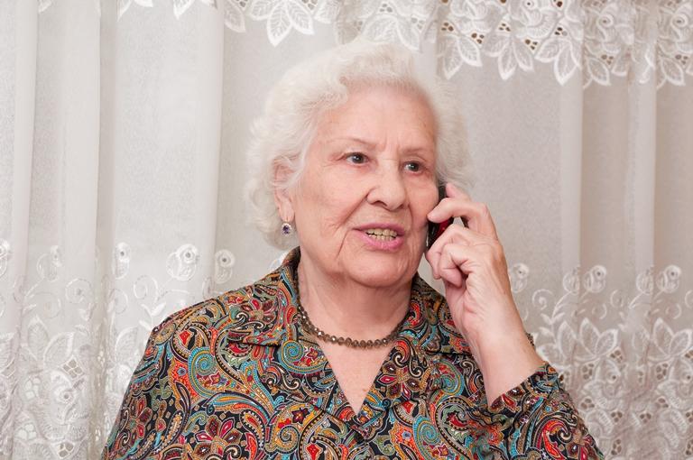 пожилая женщина говорит по телефону