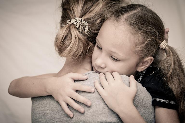 грустная девочка обнимает маму