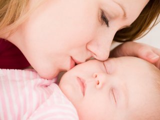 женщина целует своего ребенка