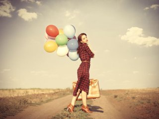 девушка с воздушными шариками и чемоданом