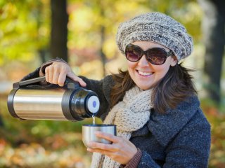 Женщина с термосом в осеннем парке