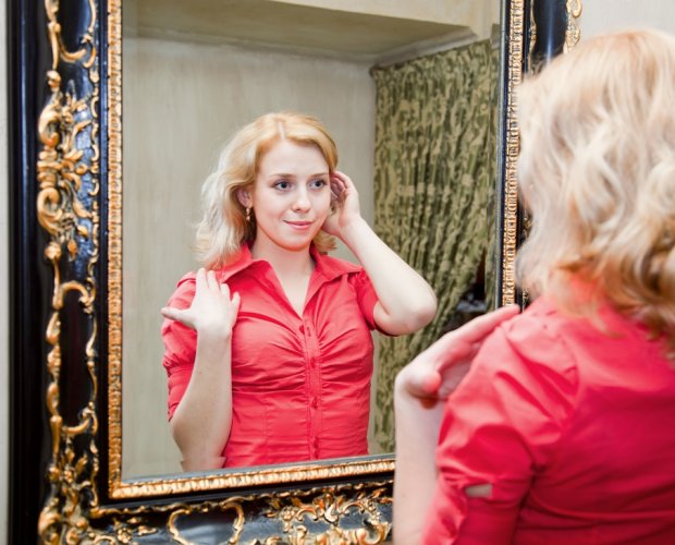 женщина смотрит в зеркало