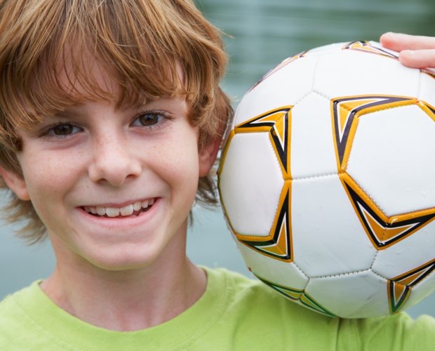 мальчик держит футбольный мяч