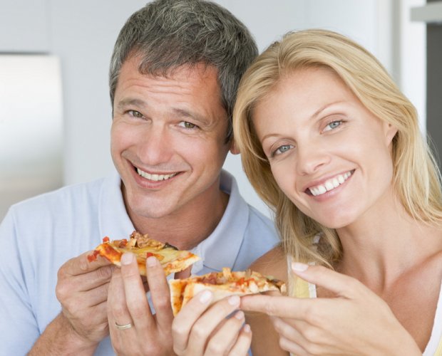 Счастливые супруги едят пиццу